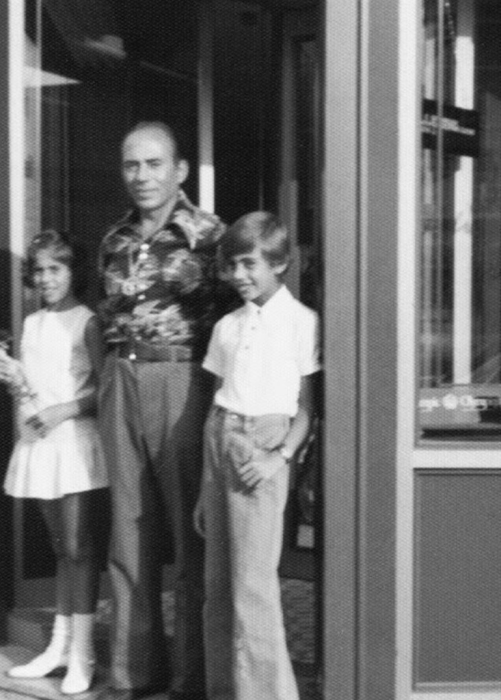 black and white image of a father and his children by his side